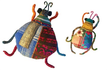 Two bugs, one bigger than the other made from scraps of fabrics. . 