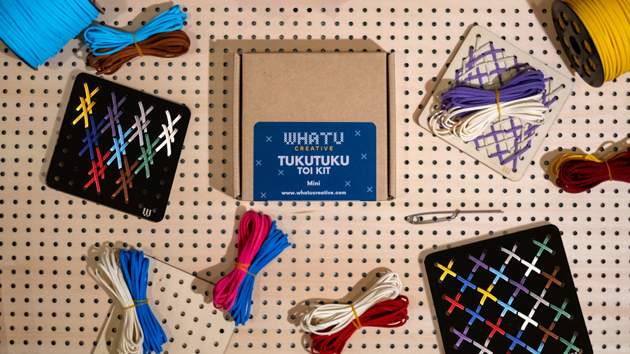 Whatu Creative Tukutuku Toi mini kits on a peg board with coloured threads and a needle.