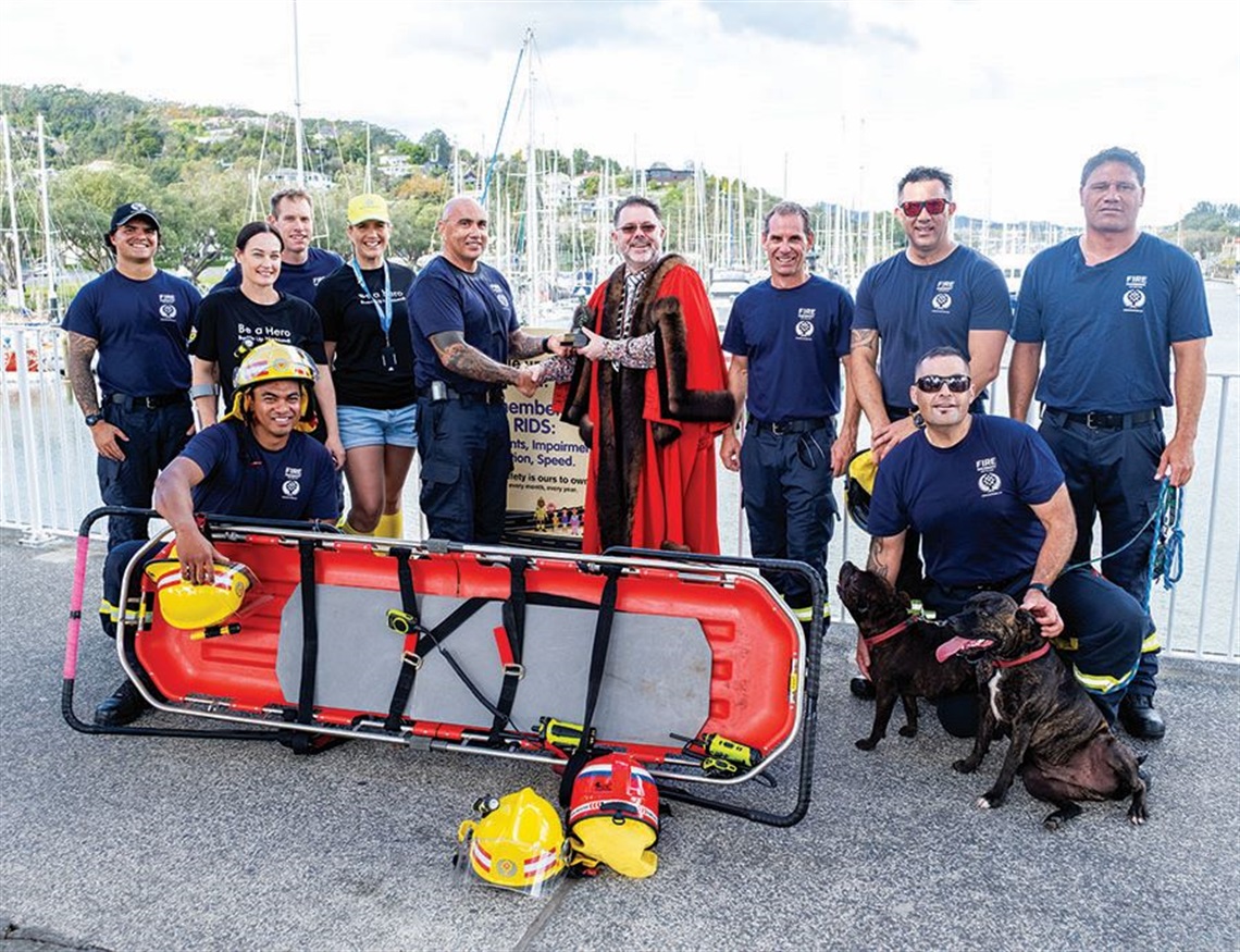 Mayor Vince Cocurullo with a group of from Fire and Emergency NZ with a stretcher and two dogs.