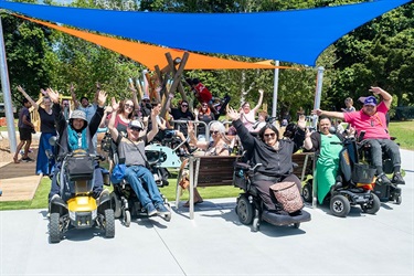 A group of wheelchair users celebrate at Raumanga Scenic Reserve Playground.