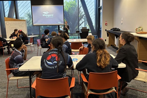 Whangarei Intermediate students sit at tables while learning about the Knowledge Precinct Plan. 