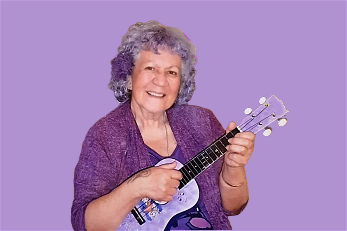 Woman holding a purple ukelele