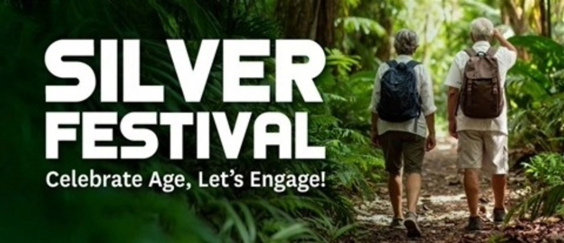 Two older adults walking on a forest path surrounded by lush greenery, wearing backpacks and casual hiking clothes. Text reads: 'SILVER FESTIVAL – Celebrate Age, Let's Engage!
