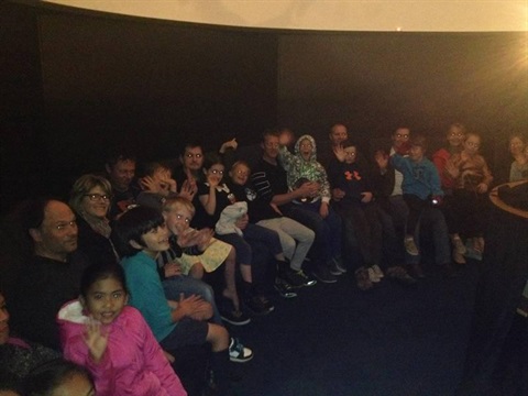Image of a group sitting under the dome for the presentation. 