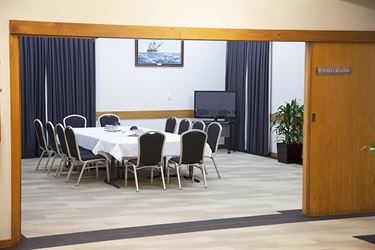 Outside angle of the Bounty Room in a meeting layout with tables and chairs setup.