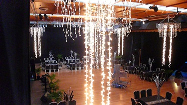 Exhibition Hall cocktail layout with lights hanging from the ceiling with tables and chairs setup.