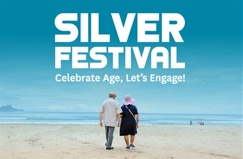 Promotional tile for “Silver Festival” with the tagline “Celebrate Age, Let’s Engage!” in large white text over a teal-blue sky. In the foreground, two older adults walk away from the camera along a sandy beach toward the ocean. 