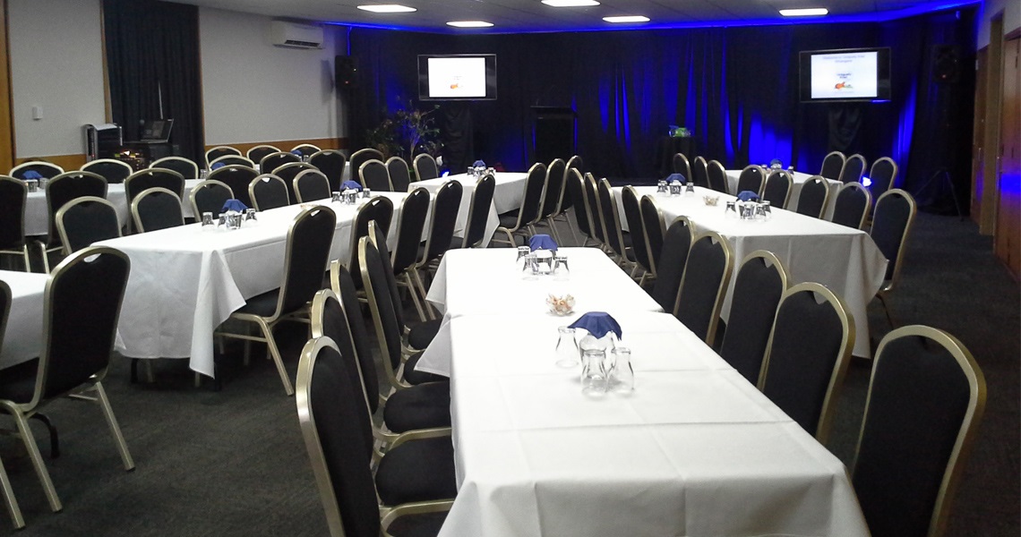 Photo of the Cafler Suite set up as a cabaret or banquet layout with lighting. 