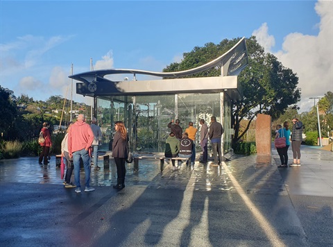 Picture showing people in front of the Rolling Ball Clock. 