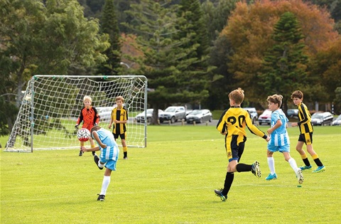 Young boys playing soccer at a sports park. 