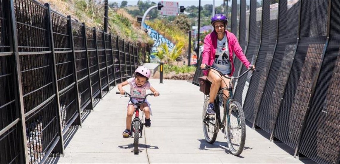 A woman and child riding on the Kamo Shared Path. 