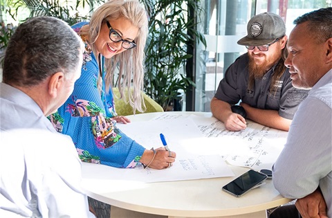 Four people in a meeting around a table.